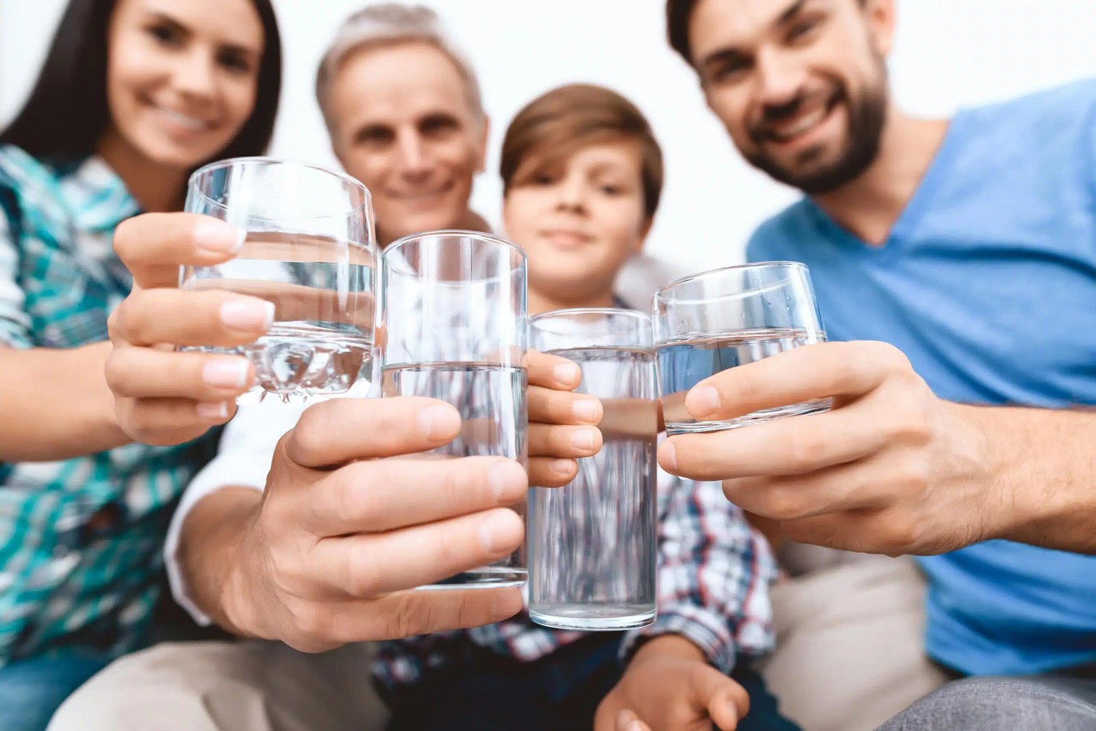 close up cheerful family cheering with glasses water min scaled.jpg